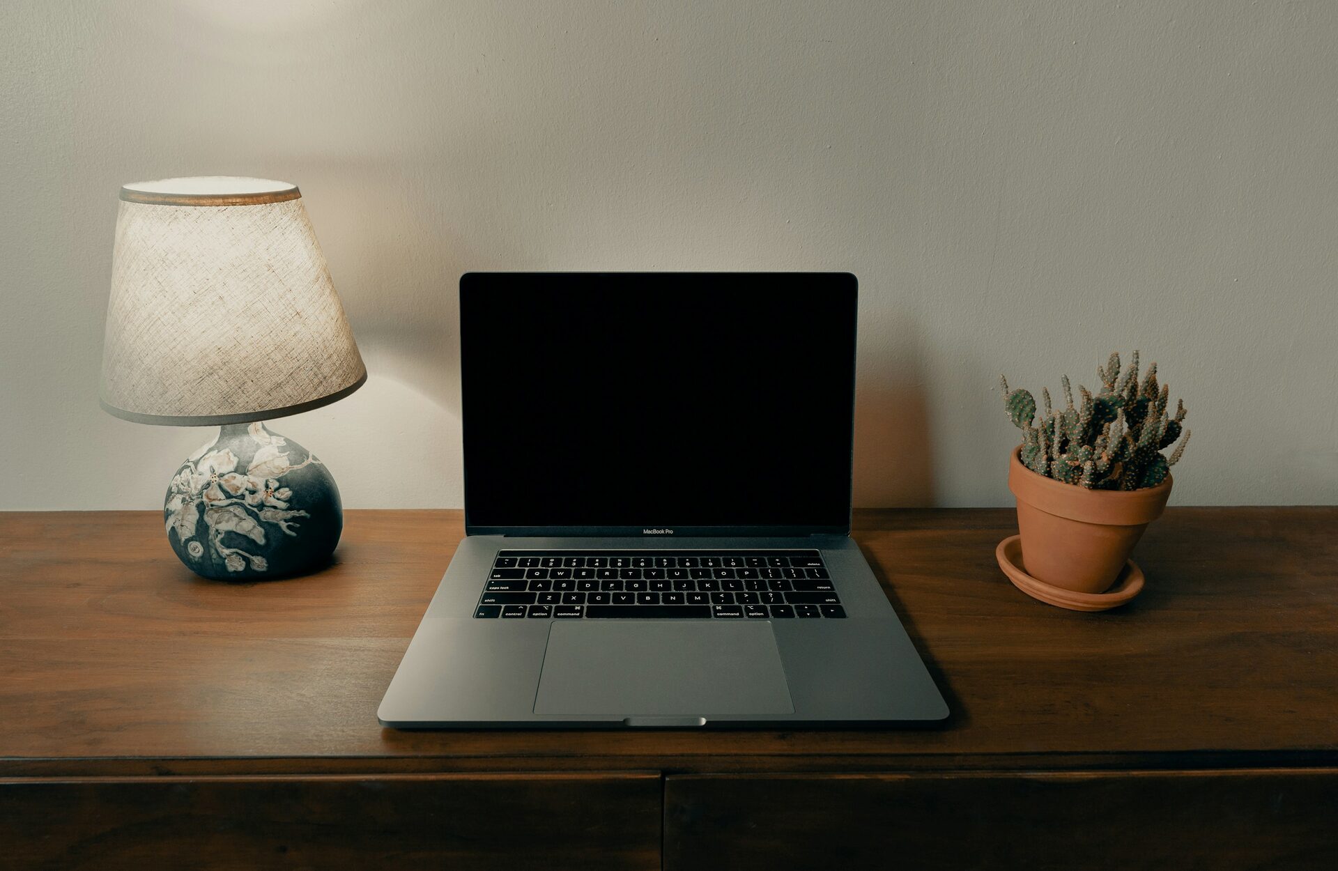 MacBook Pro open on a warm brown wooden desk