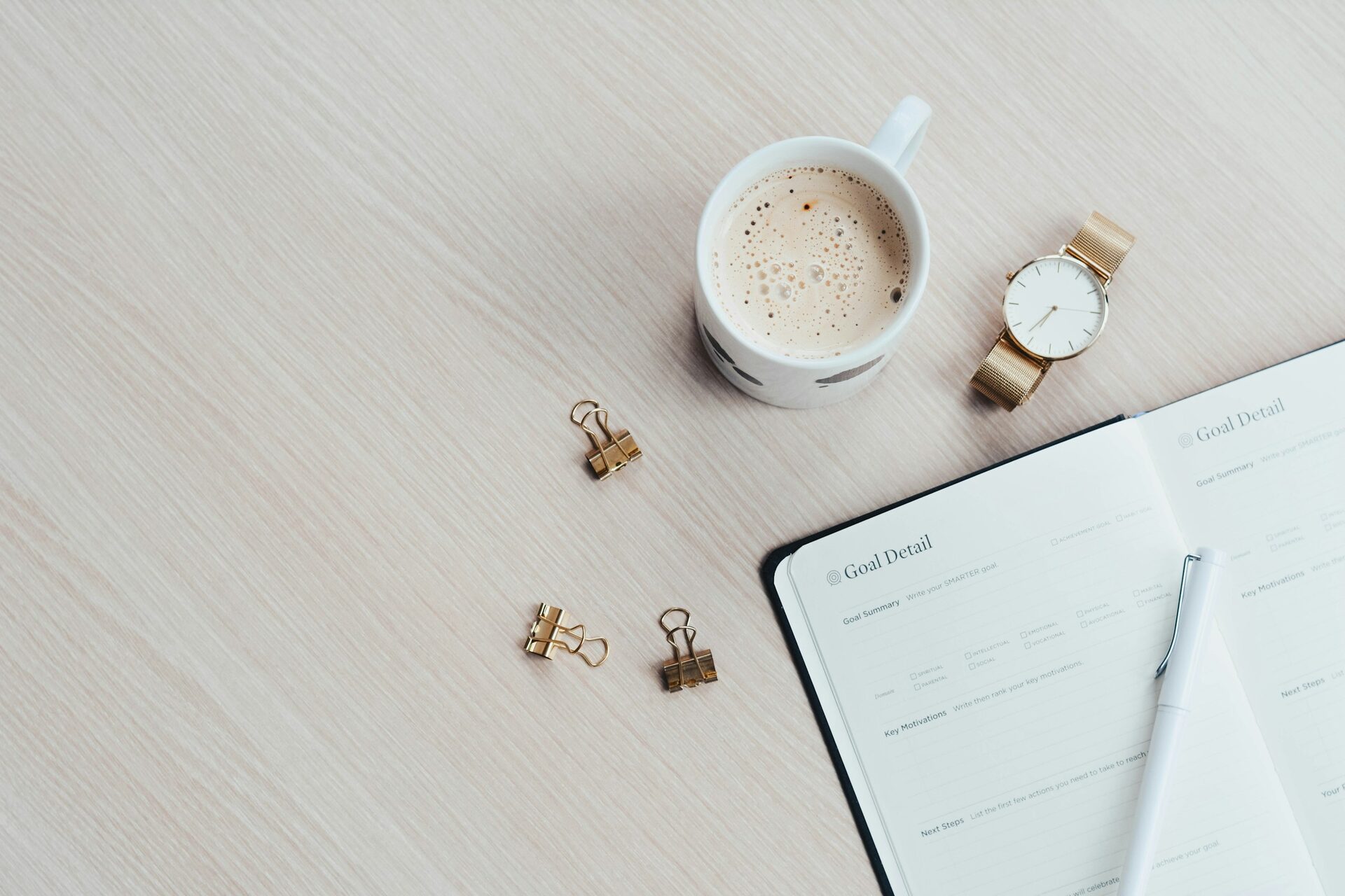 white paper pages beside a filled coffee mug on a warm desk